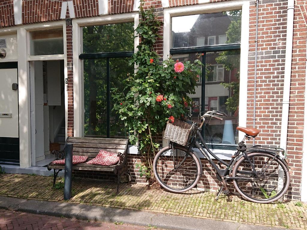 吕伐登Bed in de binnenstad ♡ bed downtown的停在房子前面的自行车,有长凳
