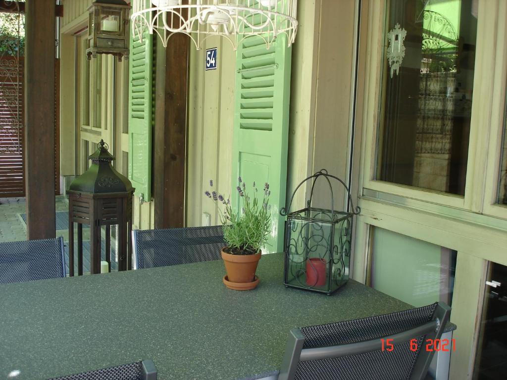 ThörishausLeimernhof的坐在门廊上的桌子和盆栽植物