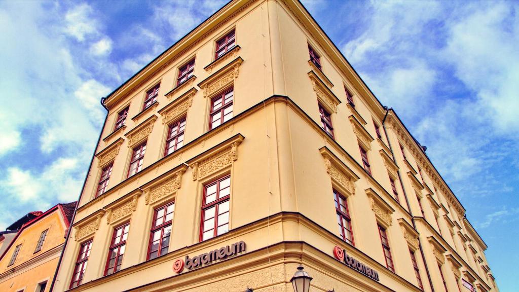 赫拉德茨 - 克拉洛韦博曼公寓式酒店的一座黄色的建筑,上面有一座塔