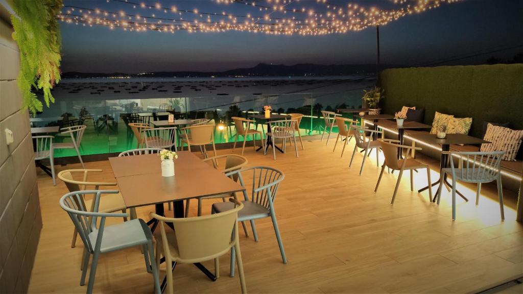 里博雷多Hotel Mirador Ría de Arosa的一间带桌椅和灯光的餐厅