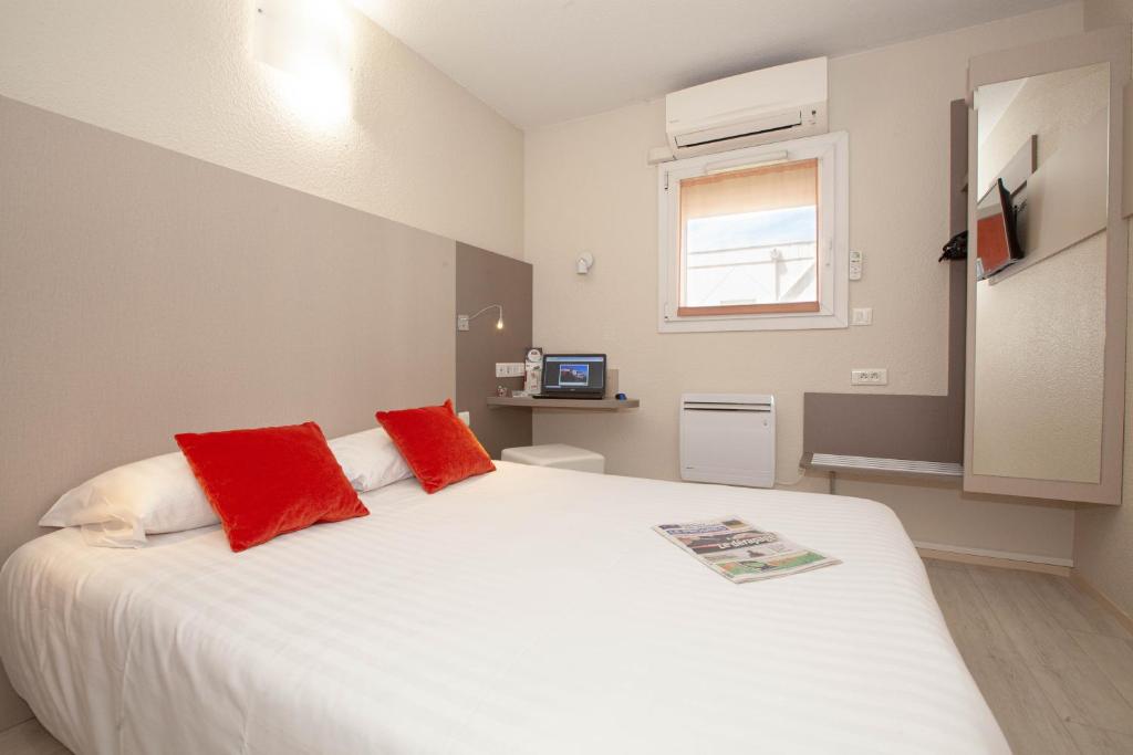 圣普列斯特最佳集团里昂圣普利斯特酒店的卧室配有带红色枕头的大型白色床