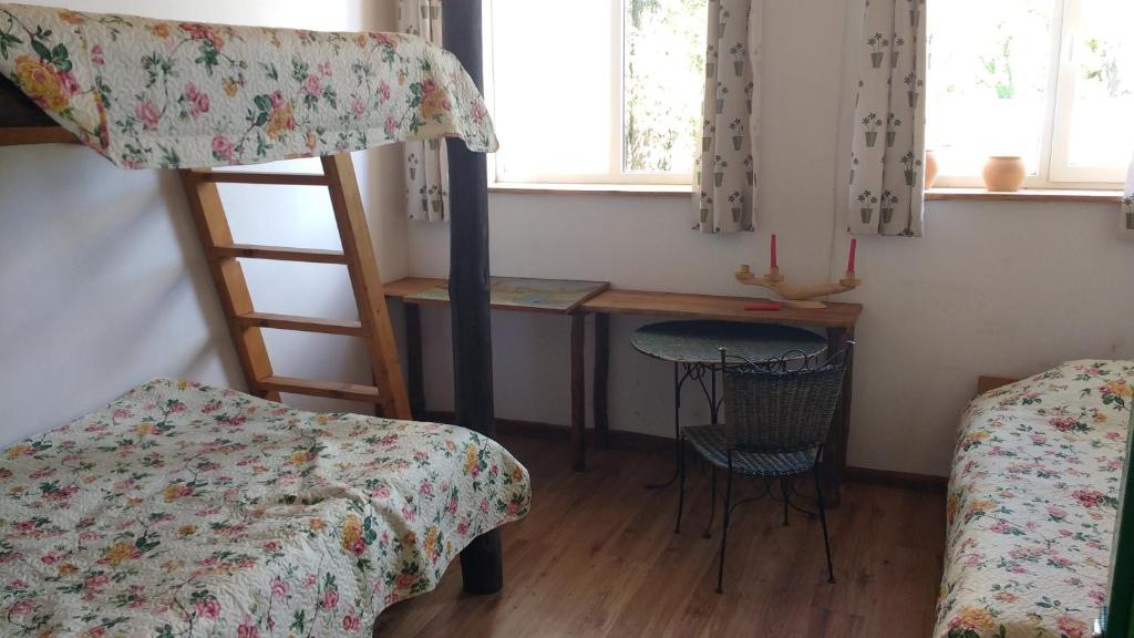 KernavėKernaveland的一间卧室配有一张双层床、一张桌子和一张桌子。