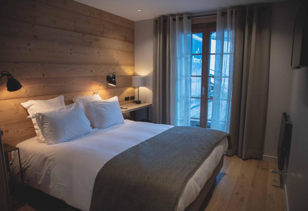 拉克吕萨农场酒店的一间卧室设有一张带木墙的大床