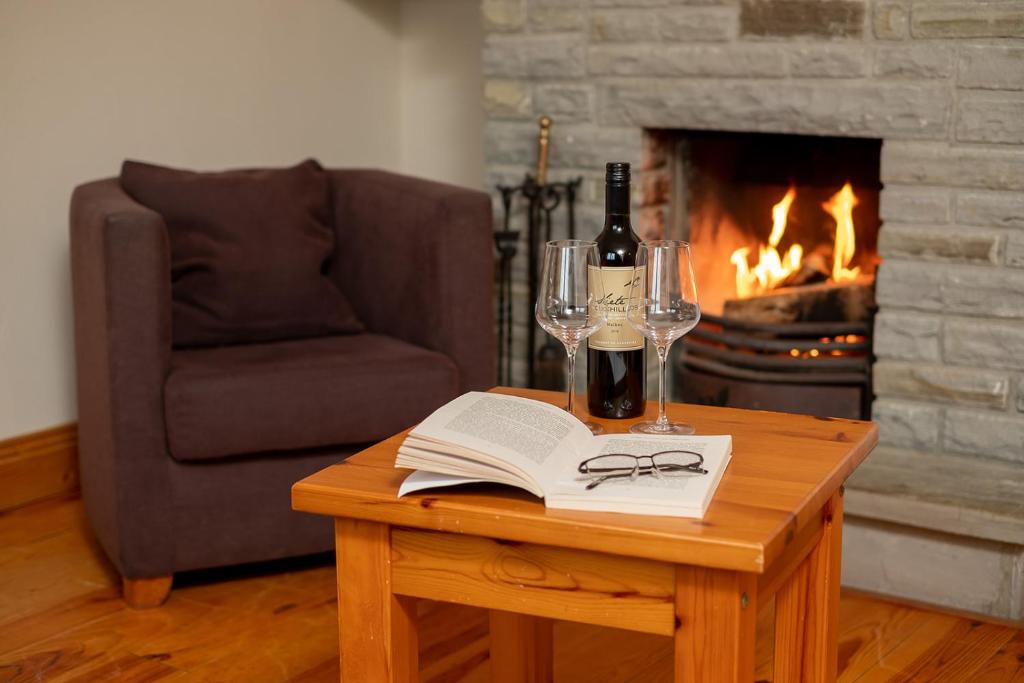 杜林Piper's Chair Houses的一张桌子,上面放有书籍和酒杯,还有一个壁炉