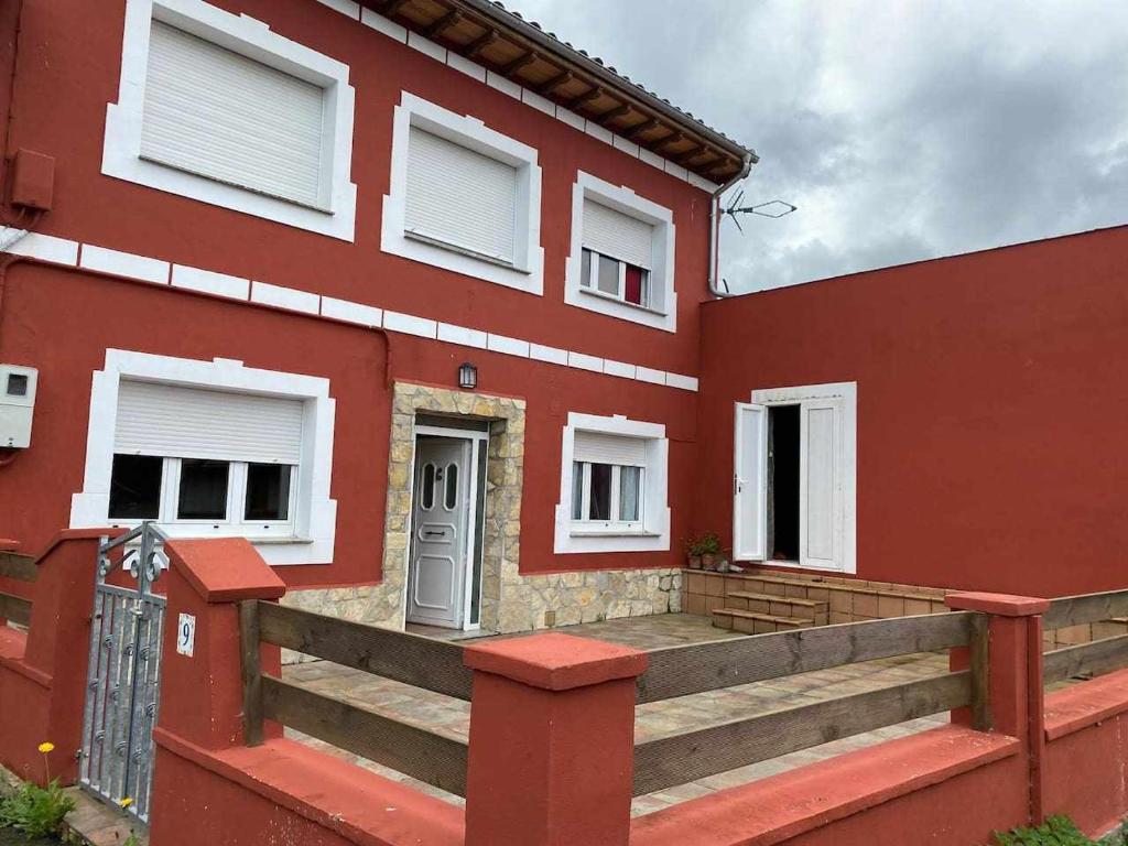 PriescaCasa Rural Mirador de Quintana的前面有木坡道的红色房子