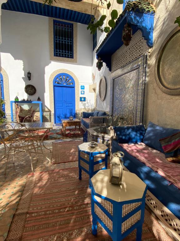 非斯让克洛德摩洛哥传统庭院住宅的客厅配有蓝色的家具和蓝色的门