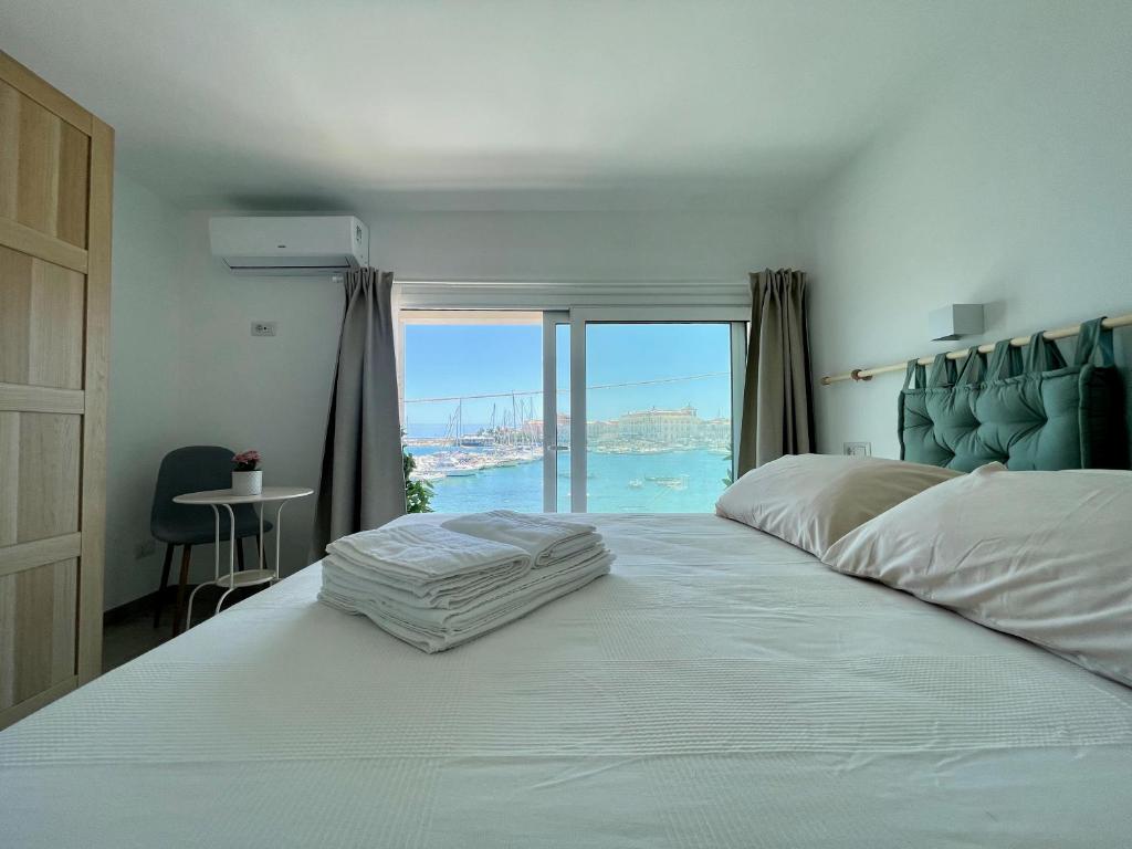 锡拉库扎Eos Sea View Apartments的一间卧室设有一张大床,享有海景