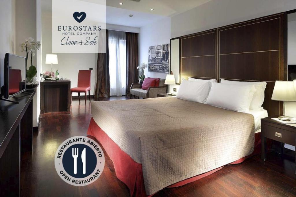 罗马埃克斯国际宫殿酒店的酒店客房设有一张大床和一间客厅。