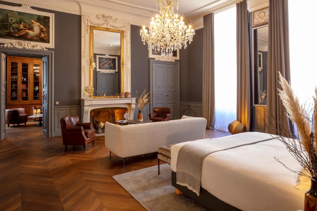 尼姆Margaret - Hôtel Chouleur的一间卧室配有一张床、一个壁炉和一个吊灯。