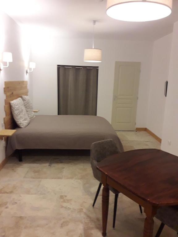 阿列日河畔的塔拉斯孔La Maison d Antoine的一间卧室配有一张床和一张桌子