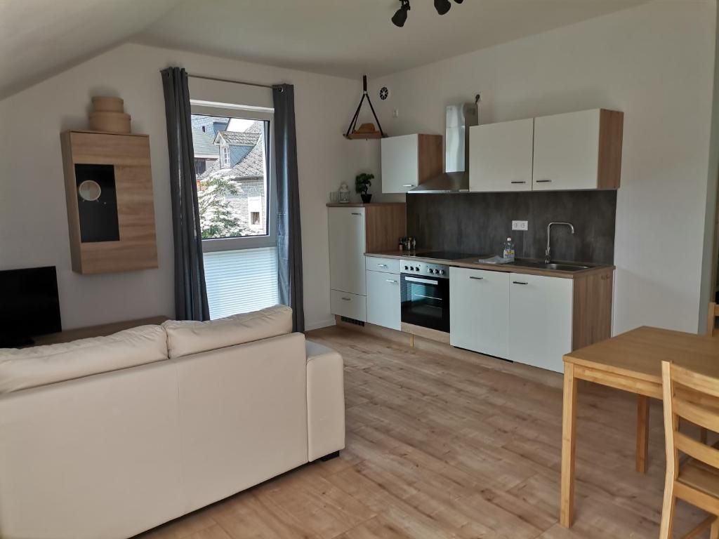 贝尔恩卡斯特尔-库斯Sonnenufer Apartment & Moselwein I的一间带白色沙发的客厅和一间厨房