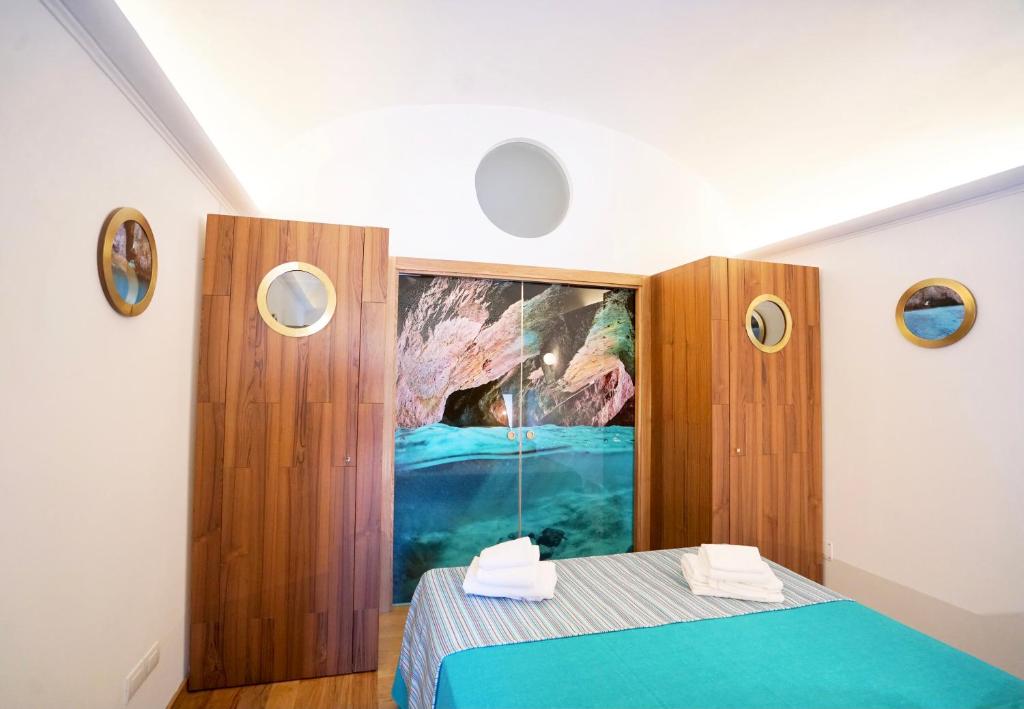 卡普里Grotta Verde Luxury Suite by CapriRooms的卧室配有蓝色的床和墙上的绘画作品