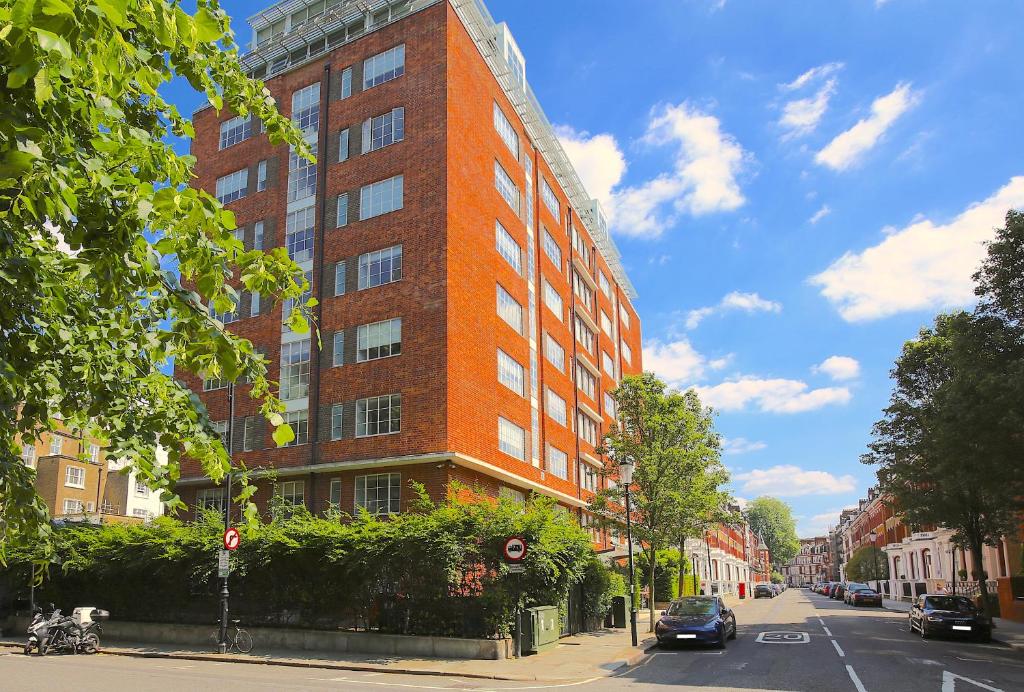 伦敦Roland House Apartments的城市街道上一座高大的红砖建筑