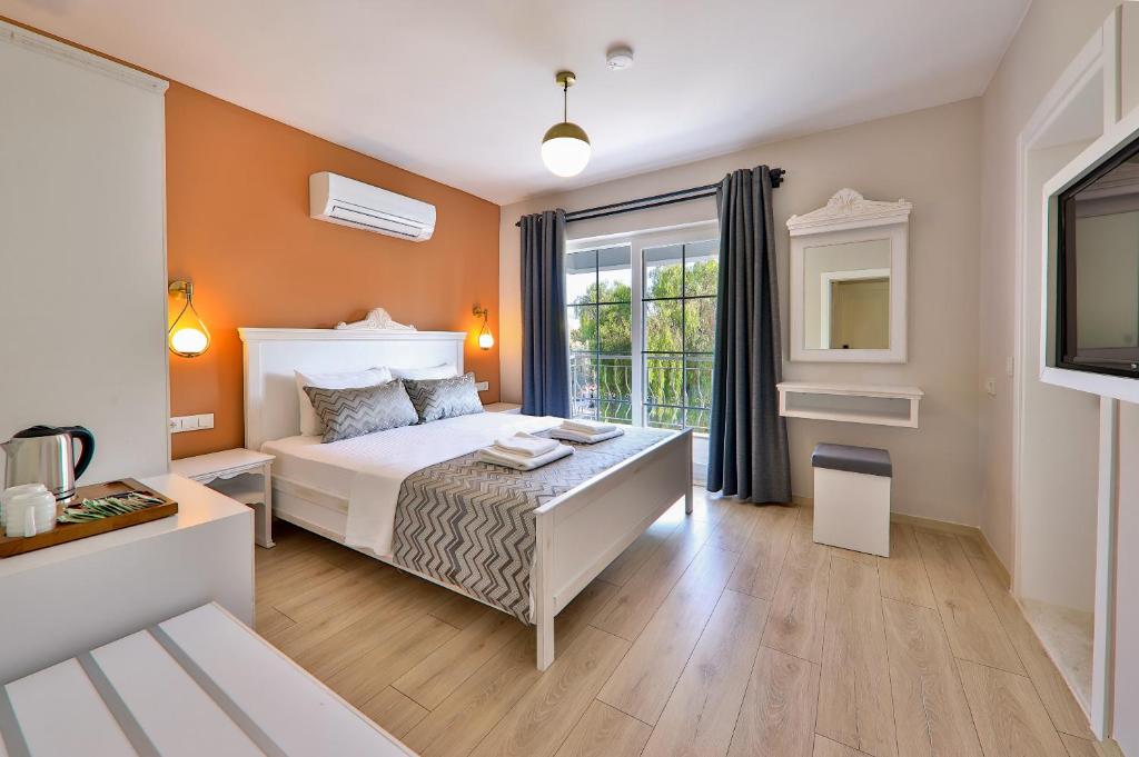 卡斯Lora Kaş Hotel的卧室配有白色的床和窗户。