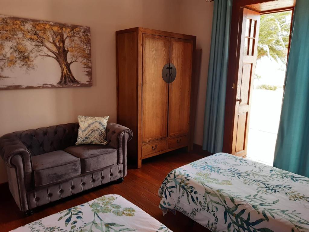 丰卡连特德拉帕尔马Casa rural Los Dragos的带沙发和床的客厅以及窗户。