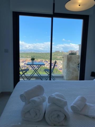 格兰阿利坎特Luxury sea view MARGOAPARTMENTS的酒店客房,配有带毛巾的床