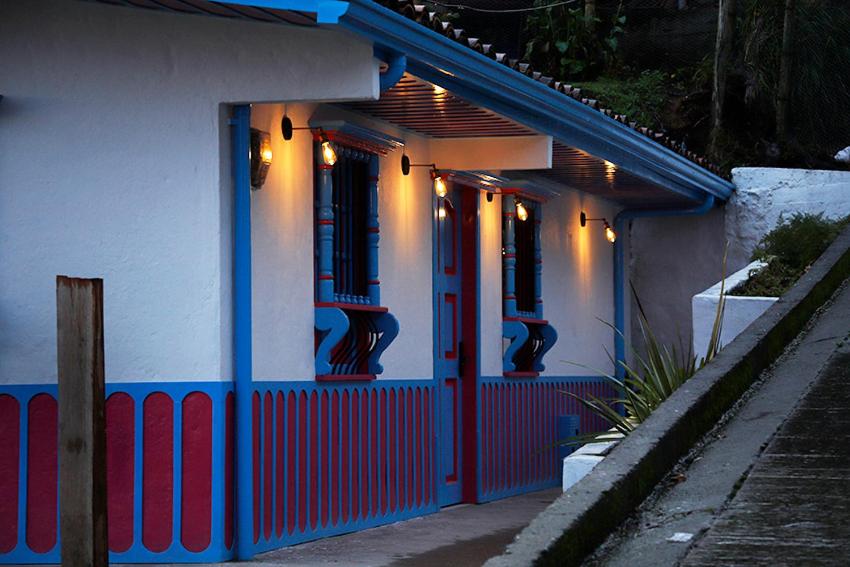 萨兰托Casa Adelina的一座拥有蓝色和红色门和灯光的建筑