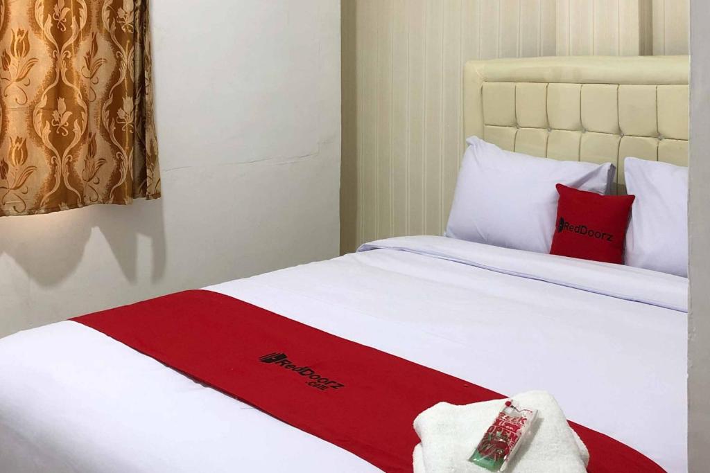 Pulauberayan DadapRedDoorz @ Aksara Medan的酒店客房 - 带两张带红色枕头的床