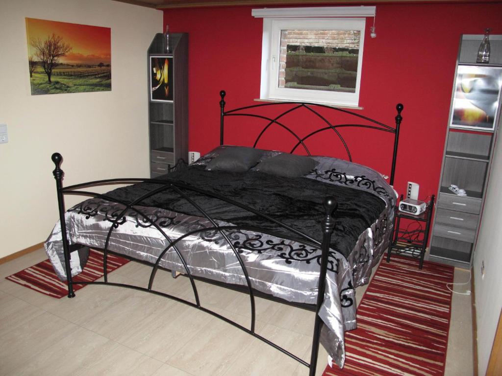 内特塔尔Nettetal - free2beme的卧室配有一张红色墙壁上的黑色床