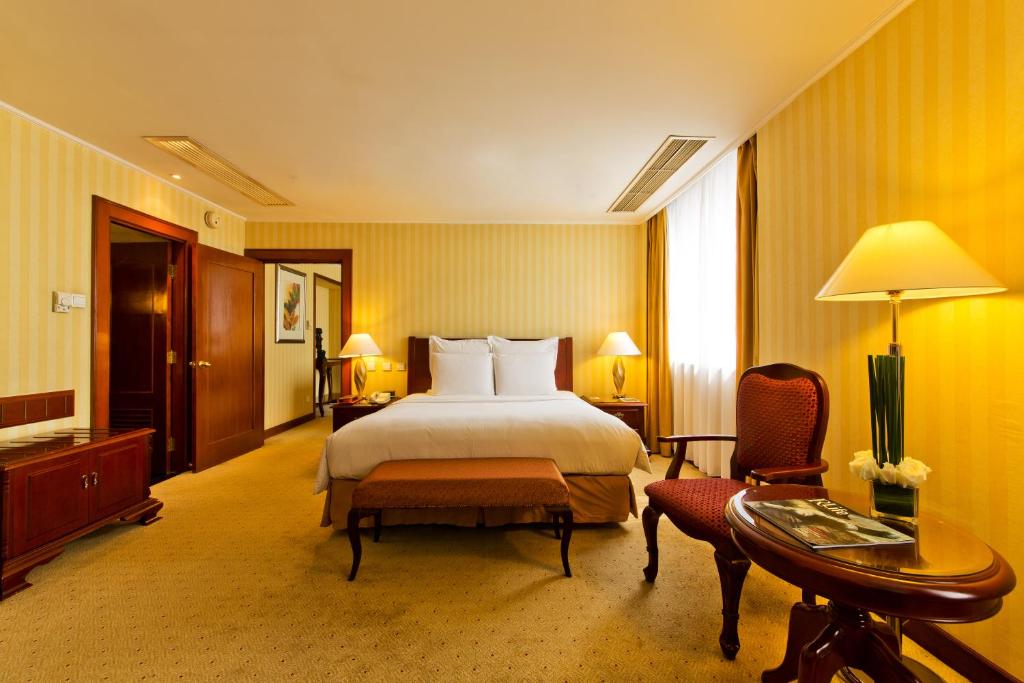 天津天津滨江凯隆酒店的酒店客房,配有一张床、一张桌子和椅子