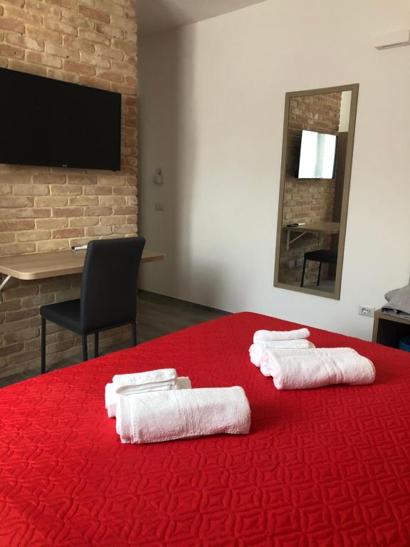 托尔托利Affittacamere Su Caboni的一间房间,配有红色的床和毛巾