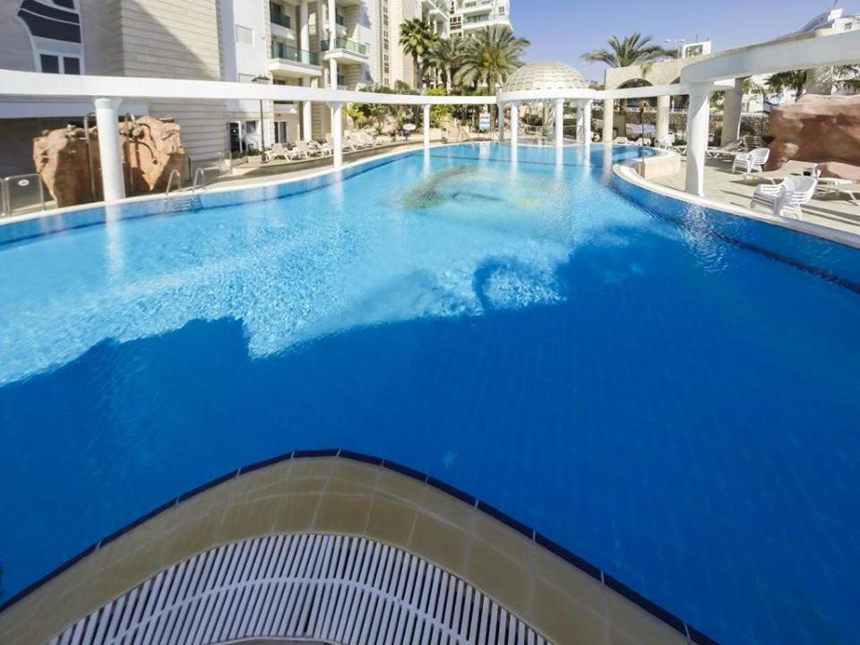 埃拉特EILAT GOLF RESIDENCE Apartment A 1的大楼里的一个大型蓝色游泳池