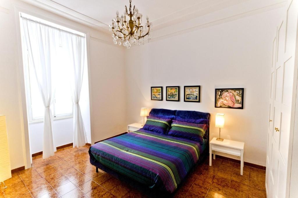 罗马圣彼得大教堂伊尔利莫度假屋的一间卧室配有一张床和一个吊灯