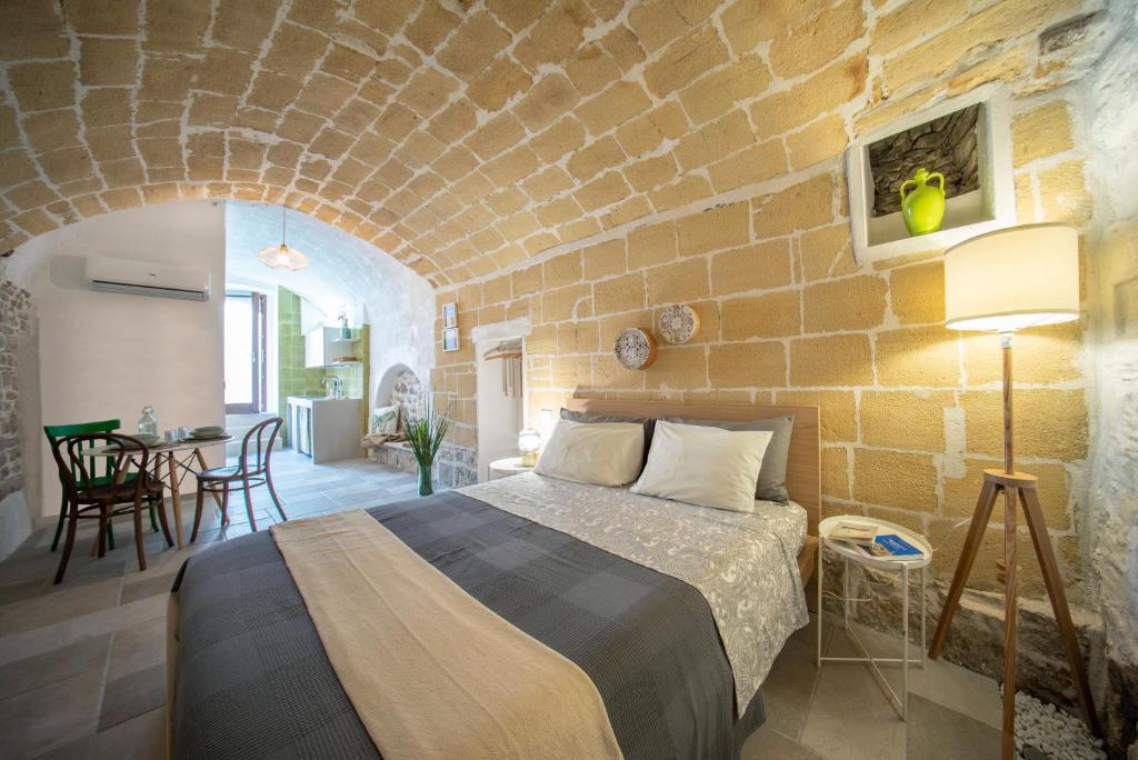 Minervino MurgeLa Ferula Magica - alloggio tipico的一间卧室设有一张床和砖墙
