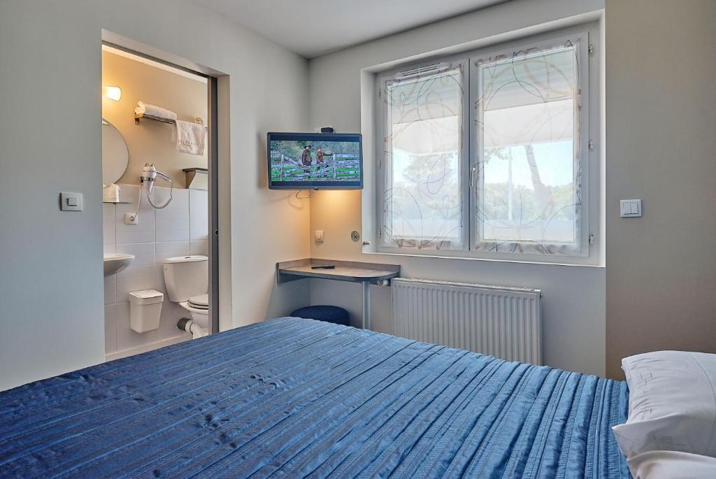 圣让-德蒙阿特兰提克酒店及餐厅的一间卧室设有蓝色的床和窗户。