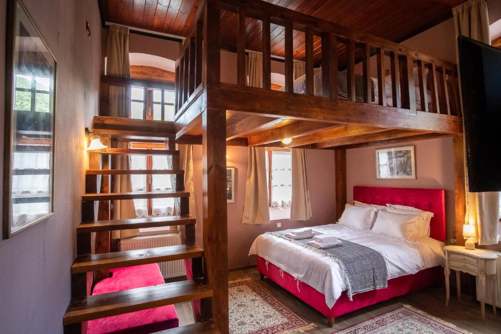 希拉科The Old School Boutique Hotel的一间卧室配有一张带红色床头板的双层床
