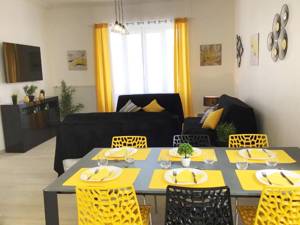 卢尔德Appartement Le Solea 100m2 climatisé parking proche Sanctuaires的客厅配有桌子和黄色椅子