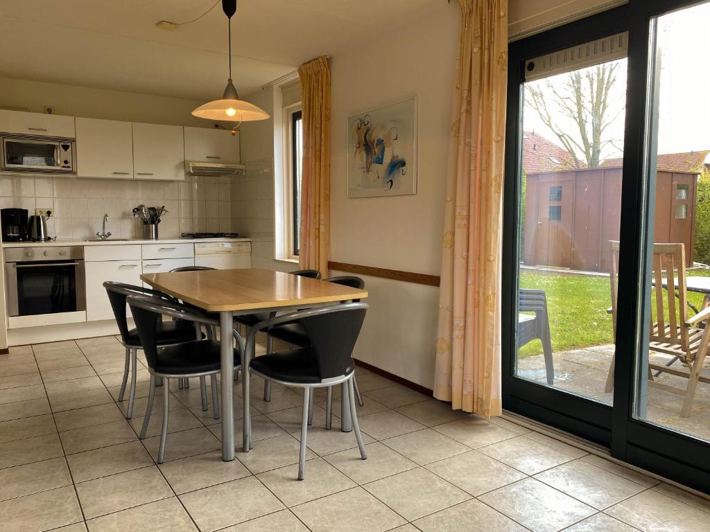 布雷斯肯斯Hello Zeeland - Vakantiehuis Stern 265的厨房配有木桌和黑色椅子