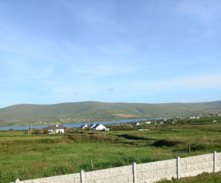 瓦伦西亚岛Country Cottage Apartment Valentia Island Kerry的水体旁边的田野上的围栏