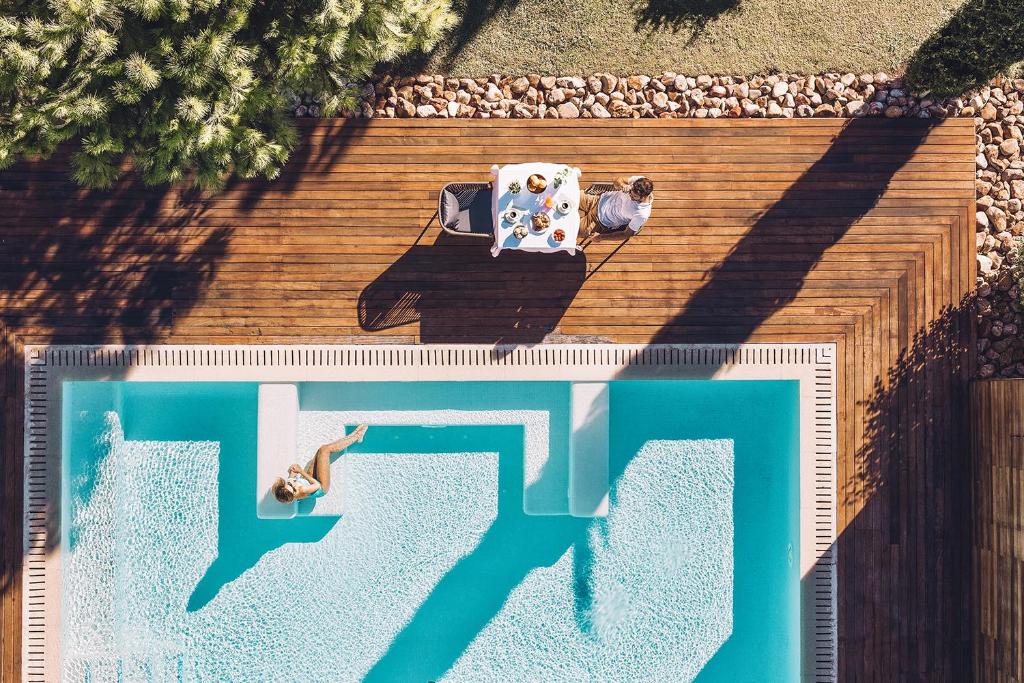 穆罗海滩海鸥套房酒店及Spa的坐在游泳池旁椅子上的男人