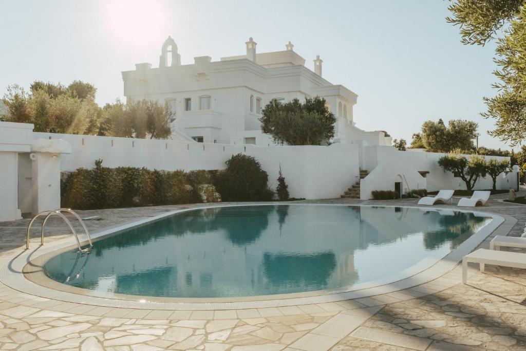 法萨诺马塞里亚博尔戈里特拉酒店的白色房子前的游泳池
