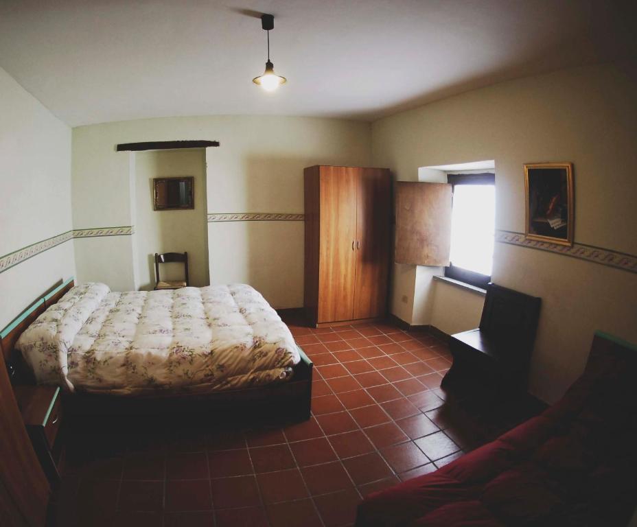 Rocca SinibaldaLa Locanda del Convento的一间卧室配有一张床和一张沙发