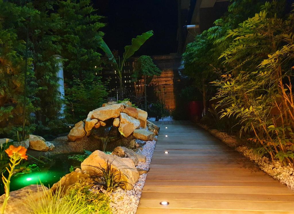 北马马亚-讷沃达里Nairi Apartment的夜间在花园里的步道上,在岩石中漫步