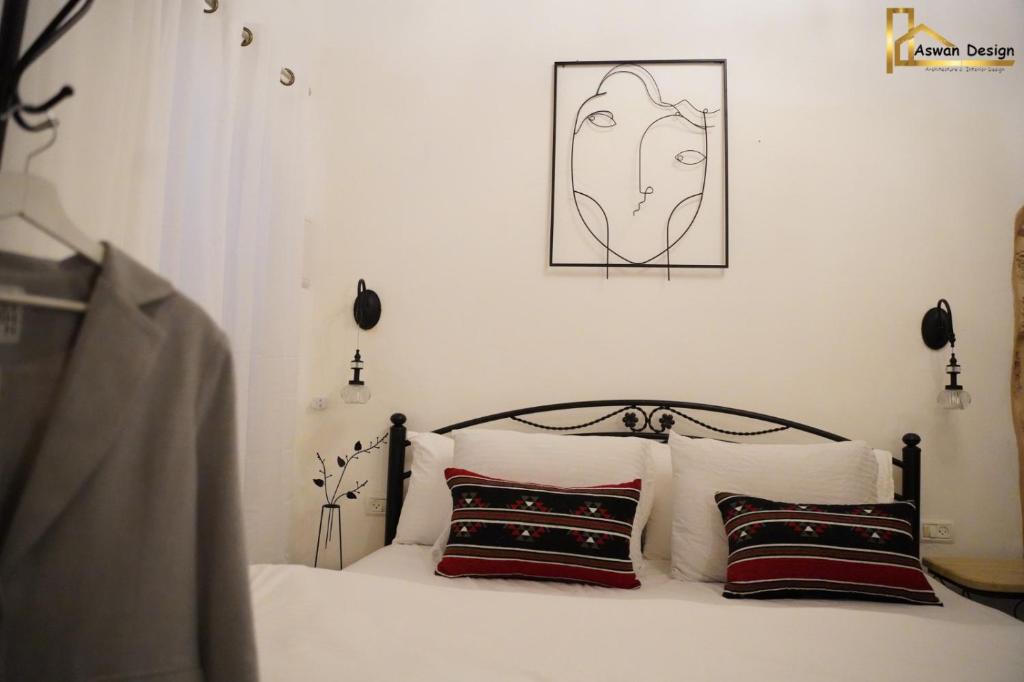 阿卡تاج عكا Taj Akko的一张带两个枕头的床和一张墙上的照片