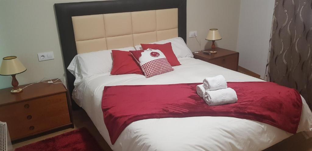 格罗韦Piso Monte Da Vila的一间卧室配有一张带红色和白色枕头的大床