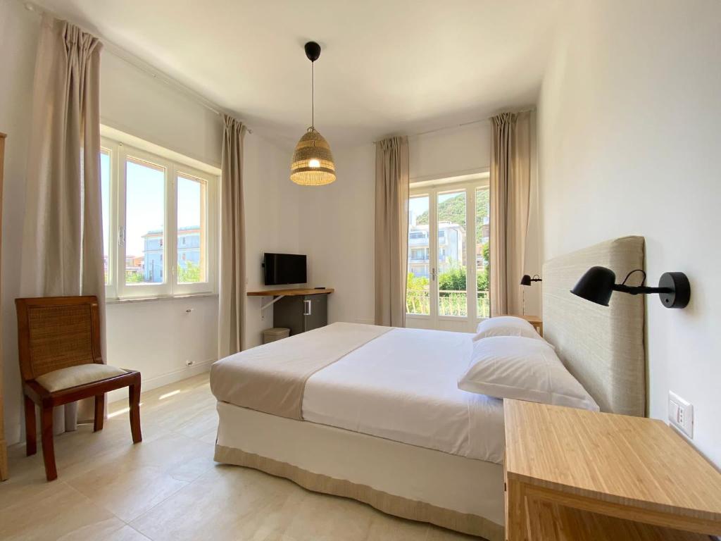 圣费利切-奇尔切奥Maison Sciscì Rooms的一间卧室配有一张床、一把椅子和窗户。