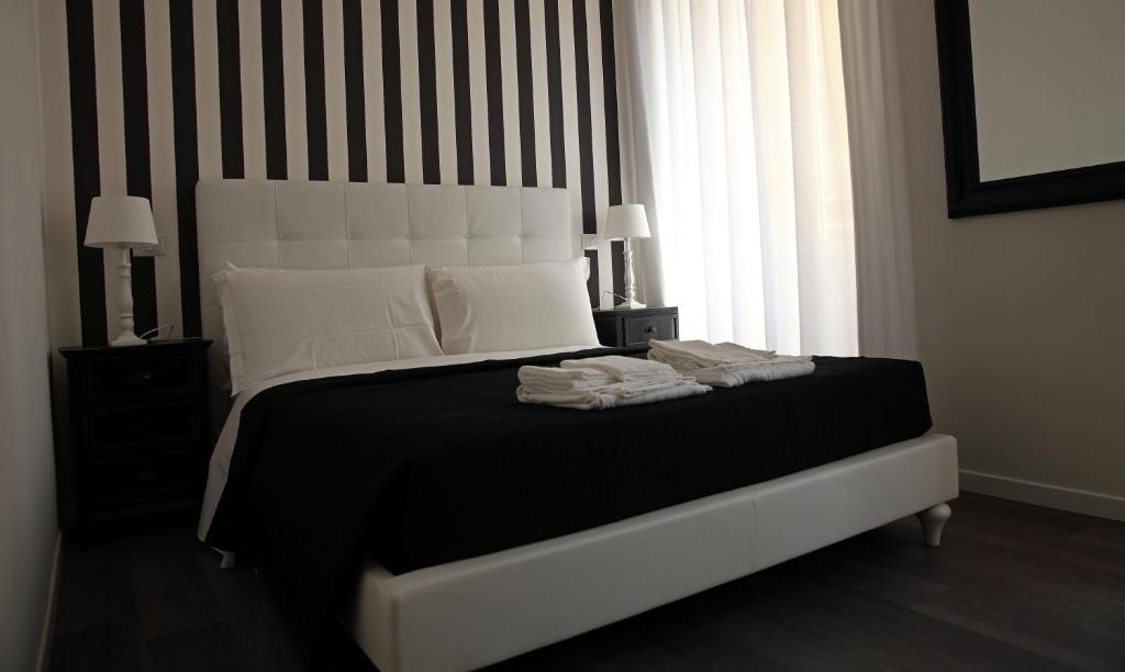 罗马弗拉米尼奥旅馆的一间卧室配有一张大床,提供黑白枕头