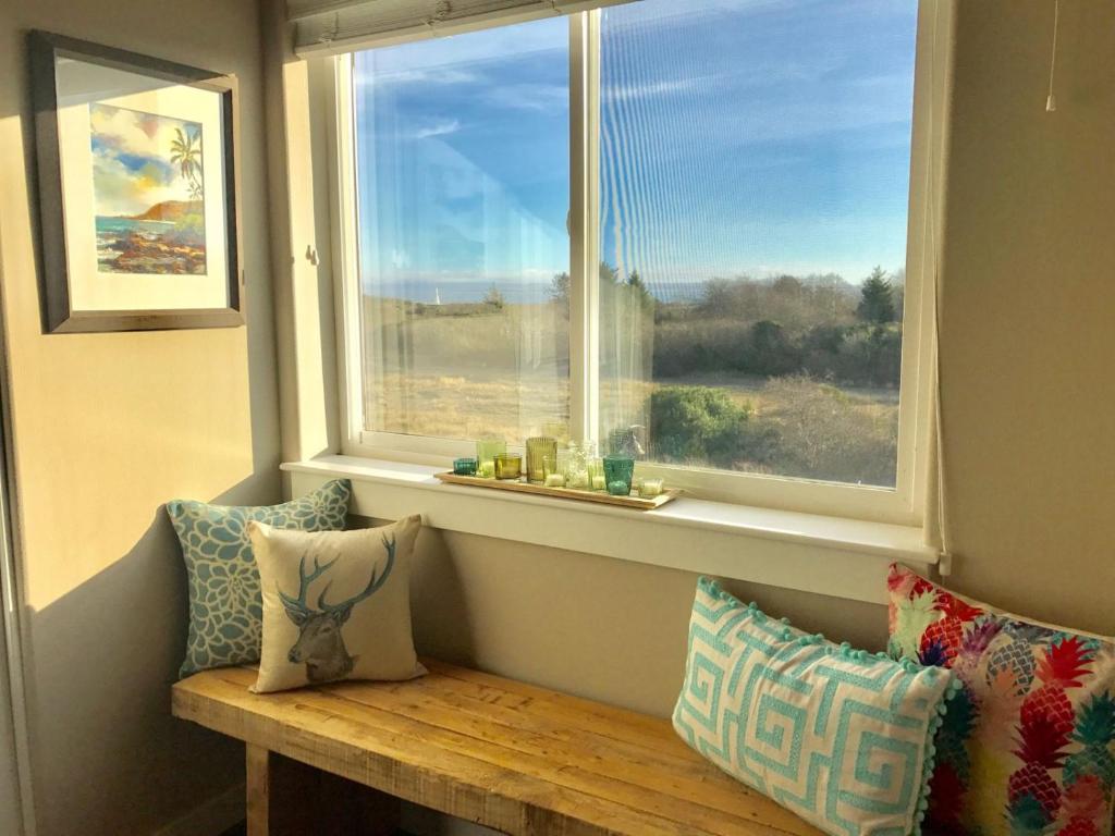 洋滨市Vista Del Mar Condo - Oyhut Bay Seaside Village的窗户前设有枕头和长凳