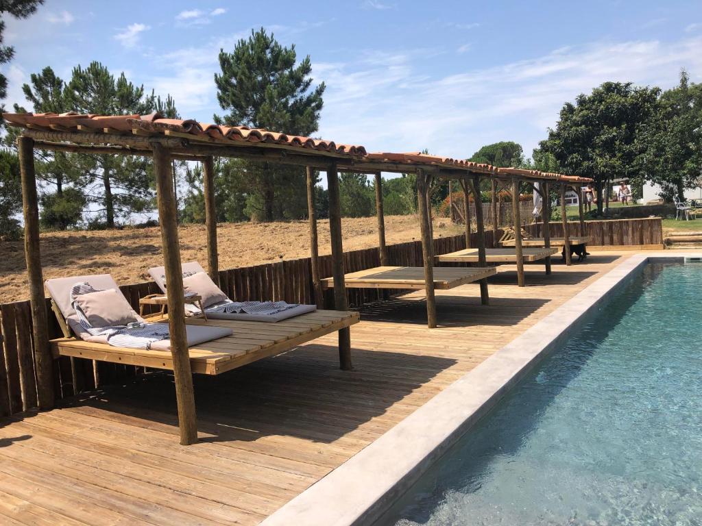 梅利迪什Ponte Pedra - Melides Country House Adults Only的游泳池旁带长椅的木甲板