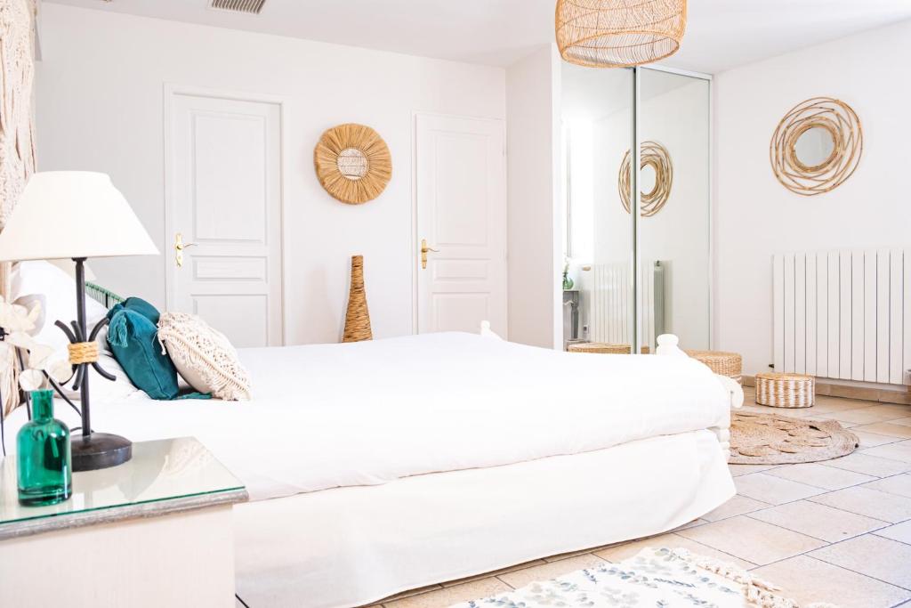 比兹米内瓦Logis hôtel et restaurant La Bastide Cabezac的白色的卧室配有白色的床和镜子