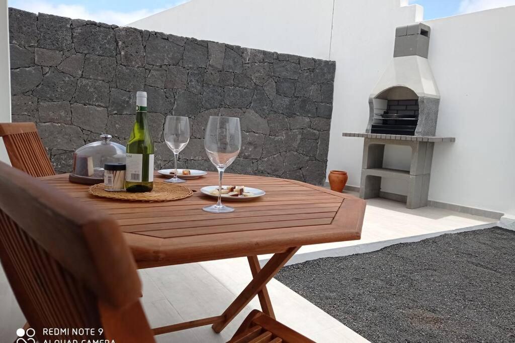特吉塞Precioso apartamento con terraza en Teguise的木桌,配有两杯酒和壁炉