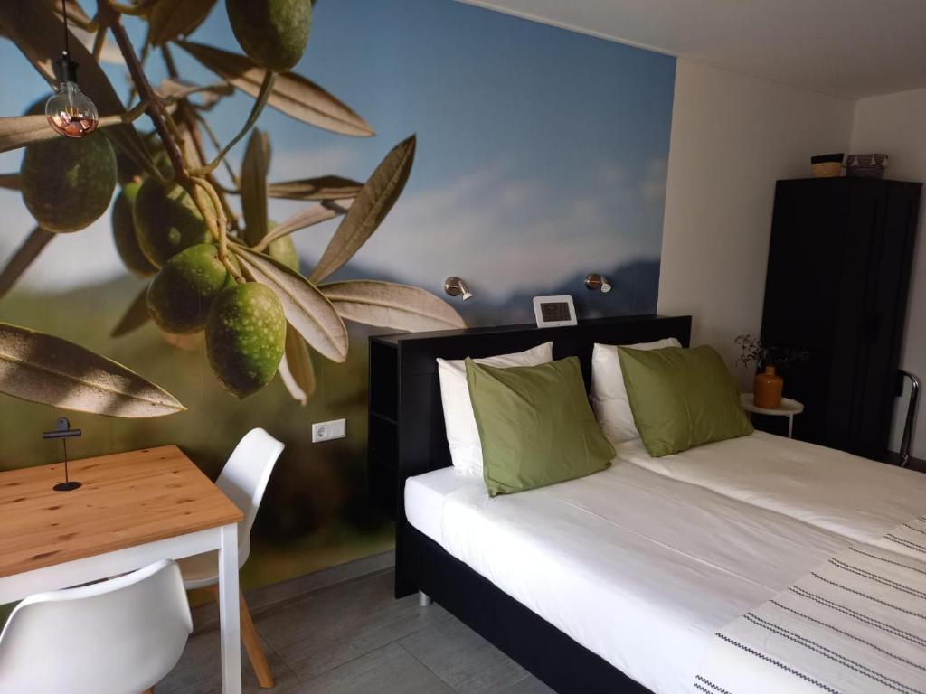 德尔纳Os Mundos的一间卧室配有床、桌子和植物