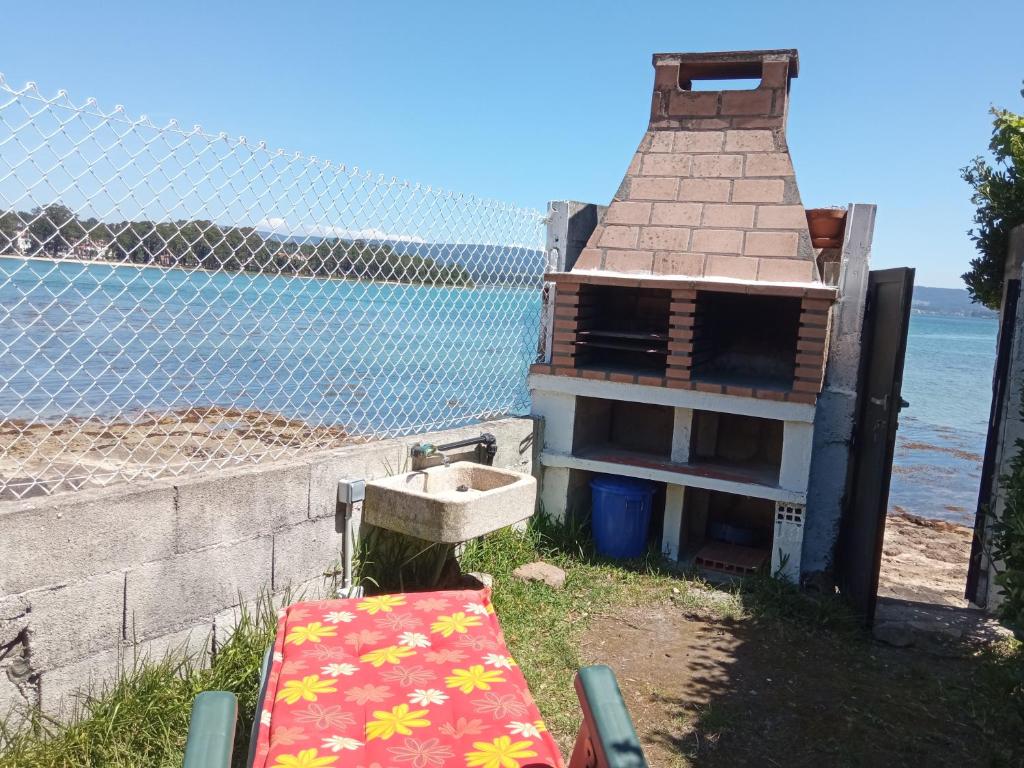 格罗韦Vistas Al Mar E Isla De La Toja的水边有水槽的建筑