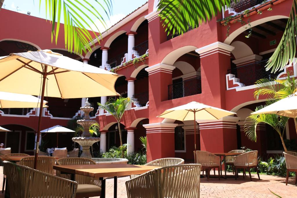 JalaNukari Quinta Boutique的大楼前的餐厅,配有桌子和遮阳伞