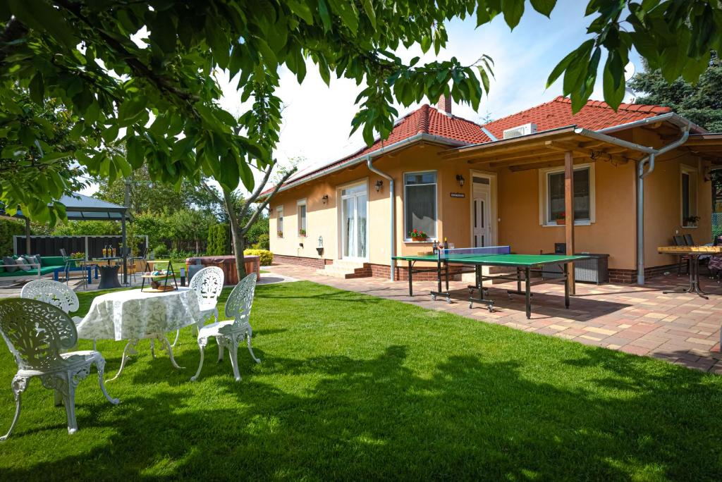 希欧福克Sunny Garden Pihenőház的一个带乒乓球桌和椅子的院子