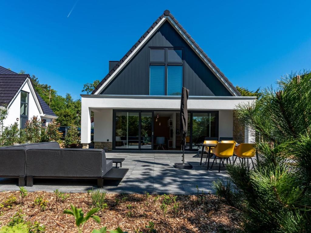 登堡Energy neutral villa with wellness area的房屋设有带黄色椅子和沙发的庭院